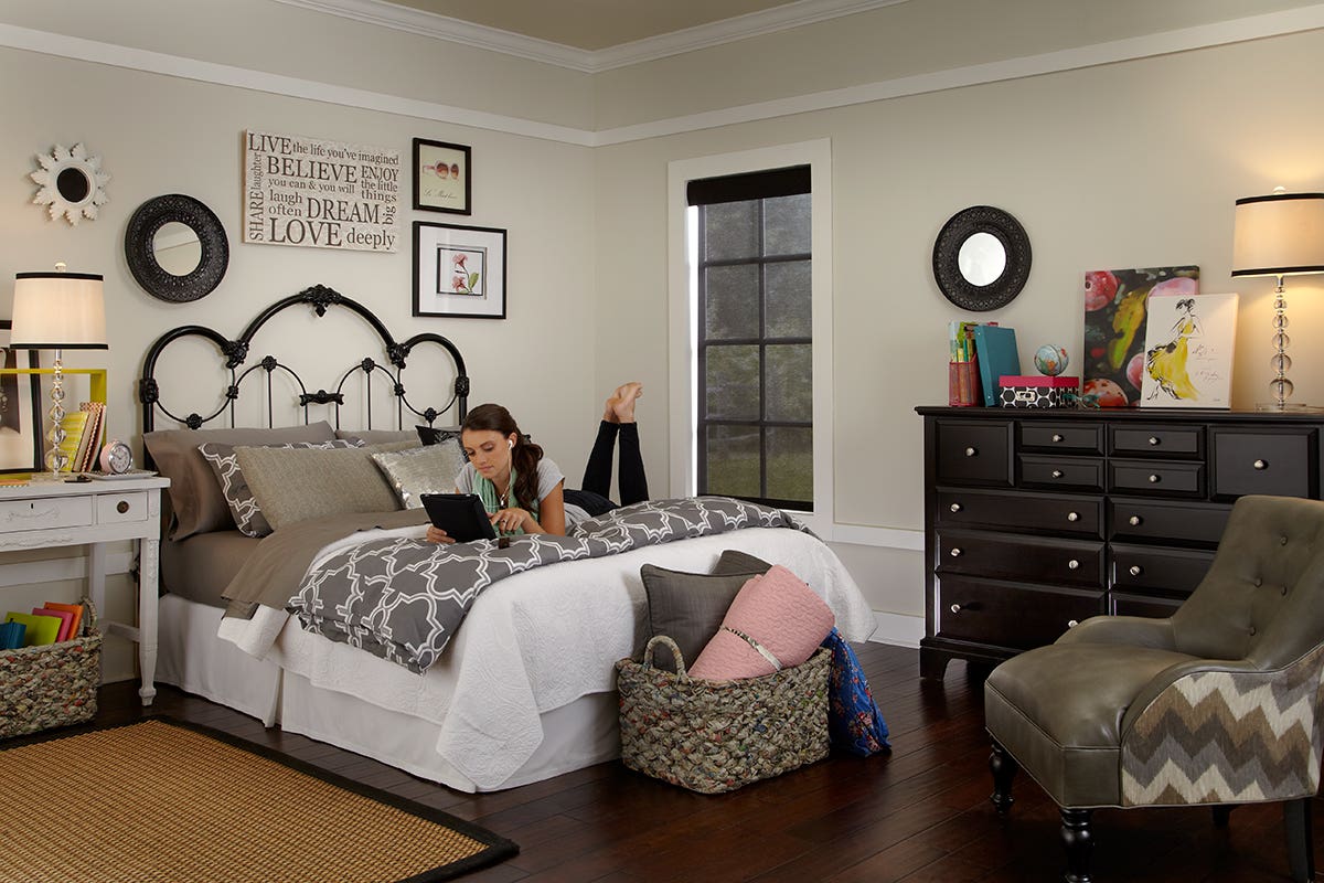 Woman Laying and Reading in Bed with Fully Closed Sheer Roller Shades