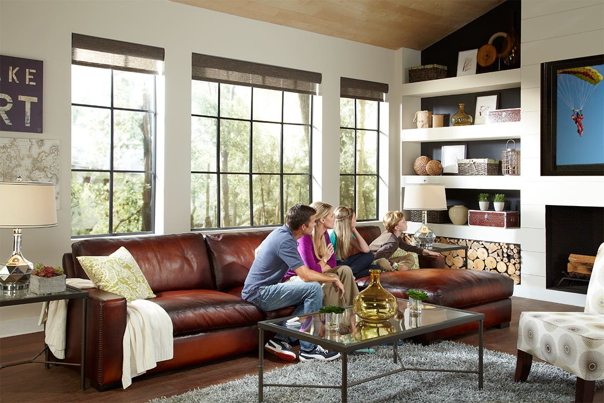 Family Watching TV in Room with Open Translucent Roller Shades