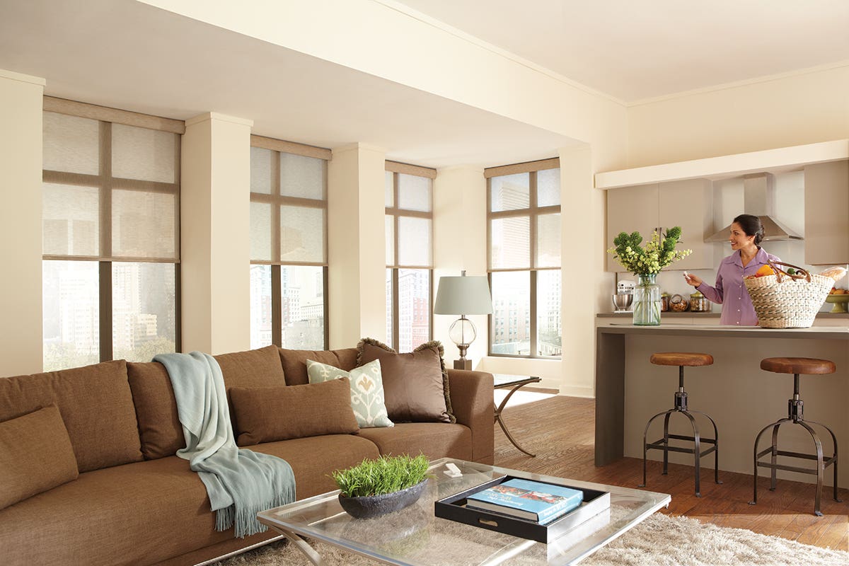 Woman in living room opening sheer roller shades