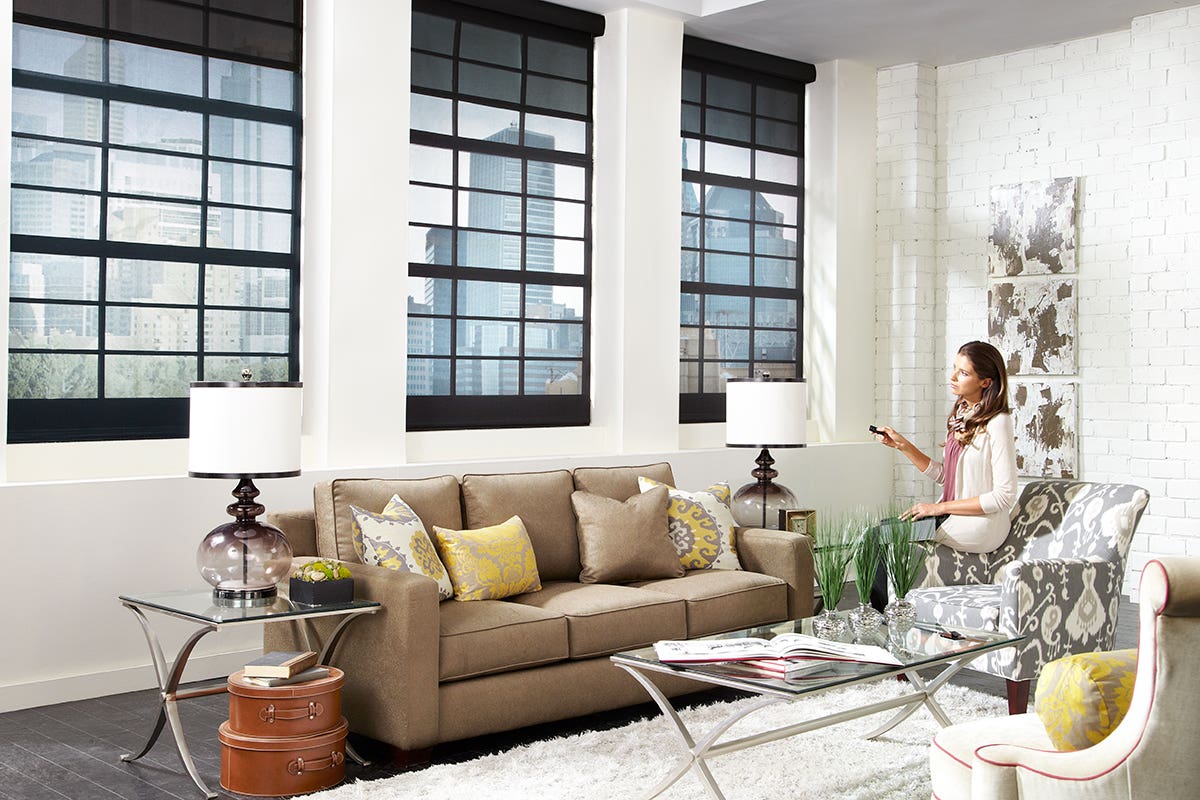 Woman Using Remote to Control Sheer Roller Shades in Charcoal