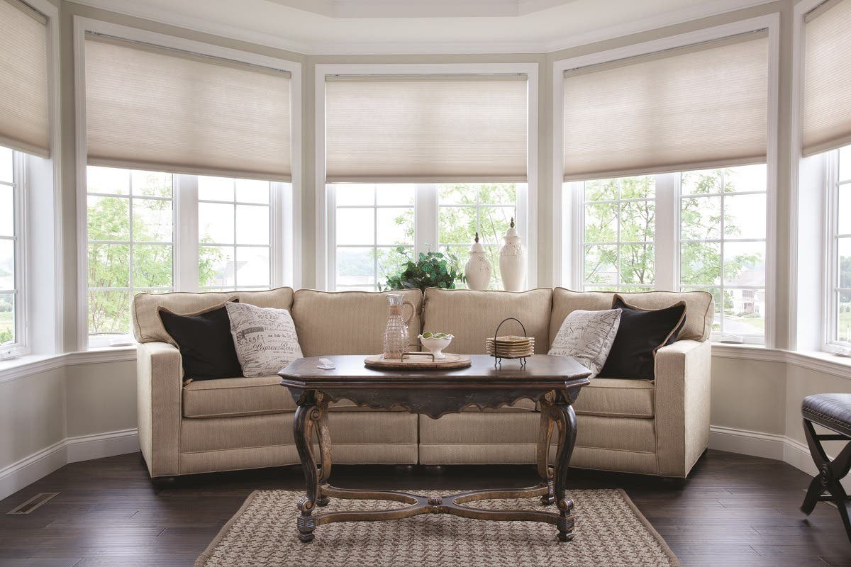 Sunroom with Empty Sofa in Front of Partially Open Honeycomb Shades