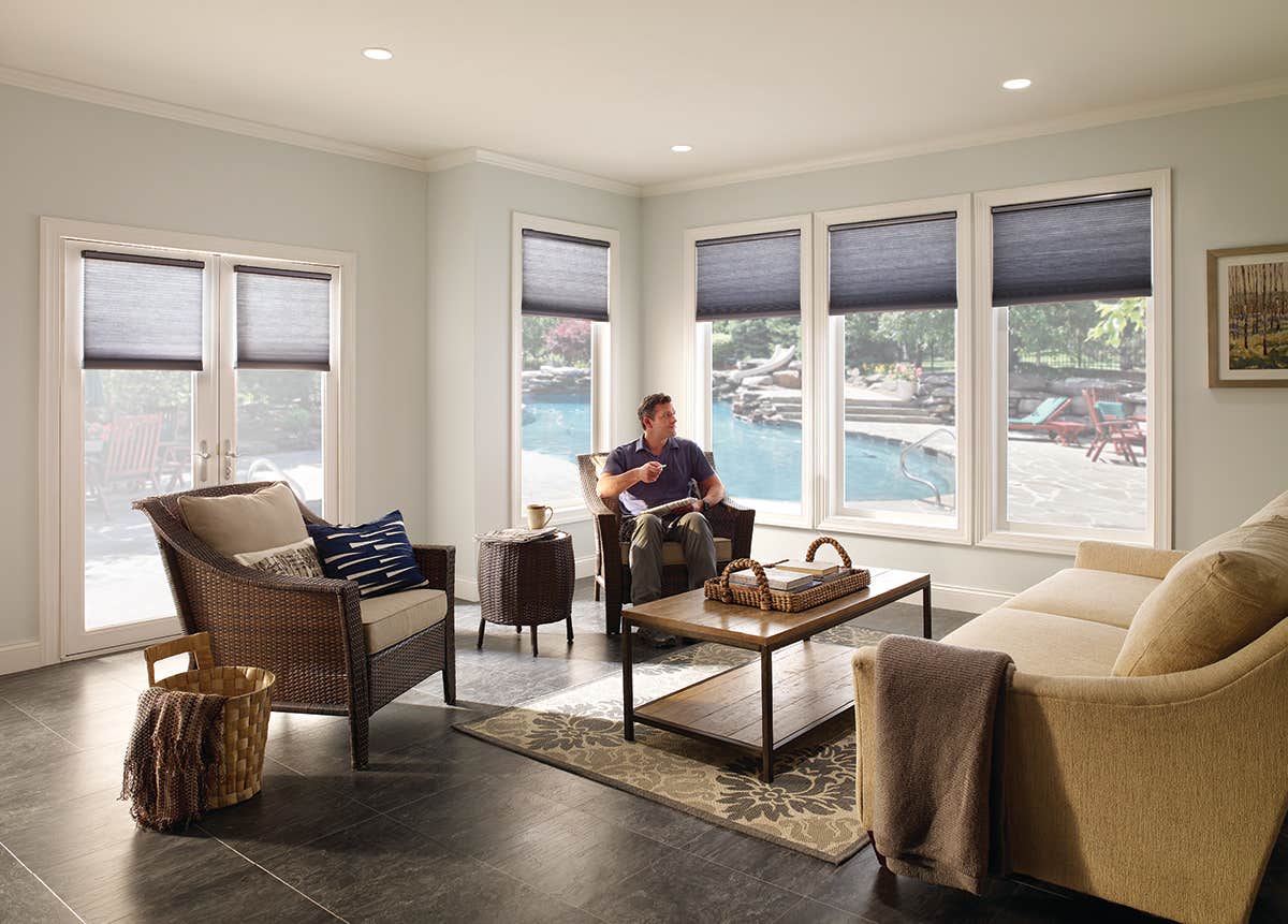 Man in Sunroom with Partially Closed Honeycomb Shades in Color Storm